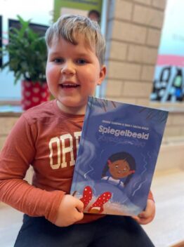 jongen houdt prentenboek Spiegelbeeld vast